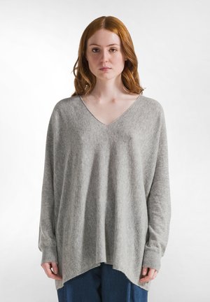 Light grey oversized sweater with a v-neck, long sleeves, and a loose fit. Soft texture with ribbed cuffs and a slightly curved hem.