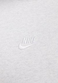 Grijze katoenen t-shirt met een wit geborduurd Nike-logo op de borst, met een zachte textuur en een klassiek crewneck ontwerp.