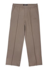 Pantalons de détente beiges en tissu doux, dotés d'une taille élastique, de deux poches latérales et d'un logo de marque discret à l'avant.