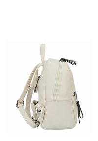 Zaino beige chiaro realizzato in materiale sintetico. Presenta un compartimento principale con zip, spallacci regolabili e una tasca laterale con dettaglio a zip.