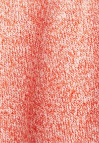 Neulottu kangas eloisassa korallinvärissä, jossa on vaaleiden ja tummien lankojen sekoitus, ja jossa näkyy kirjavan kuviollinen pinta.