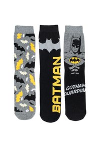 Tre paia di calzini: a sinistra grigi con motivi di pipistrelli, al centro neri con "BATMAN" in giallo, a destra neri con grafica di Batman e "GOTHAM GUARDIAN."