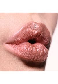 Glatte, nude læber med en blød tekstur og let glans, der fremhæver naturlige lyserøde nuancer og subtile folder, sat mod en lys baggrund.