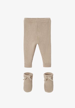 Beige Rippstrick-Babyhose mit umgeschlagenen Bündchen und passenden weichen Stiefeln mit kleinen Schleifen vorne.