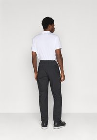 Melni bikses ar elastīgu jostasvietu, divām aizmugurējām kabatām un piegriezumu, apvienotas ar baltu t-kreklu īsām piedurknēm.