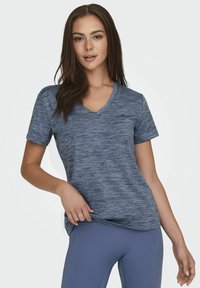 T-shirt z dekoltem w serek, krótki rękaw, wykonany z niebieskiego melanżowego materiału. Miękka textura z lekkim rozciągnięciem, z subtelnym logo na klatce piersiowej.