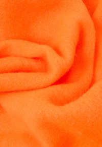 Απαλή, φωτεινή πορτοκαλί ύφανση με μαλακή, χνουδωτή υφή, που χαρακτηρίζεται από απαλές πτυχώσεις και ομοιόμορφο χρώμα σε όλη την επιφάνεια.