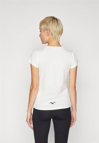 White short-sleeve T-shirt with a round neckline and black logo detail at the back hem. Cotton fabric, fitted design, and smooth texture.