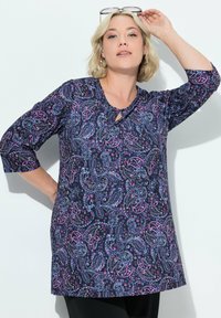 Tunic a maniche lunghe di colore blu navy con un motivo paisley rosa e blu, caratterizzata da un dettaglio a chiave nella scollatura e una vestibilità comoda.