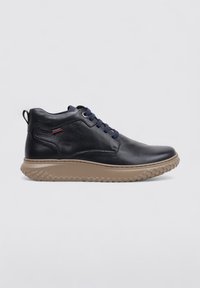 Zapato alto de cuero navy con puntera redonda, cordones azul oscuro y suela de goma texturizada beige. Presenta un pequeño logotipo en el costado.