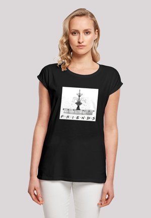 Schwarzes T-Shirt mit einem grafischen Design eines Brunnens und dem Wort "FREUNDE" darunter. Kurze Ärmel, entspannte Passform, Baumwollmaterial.