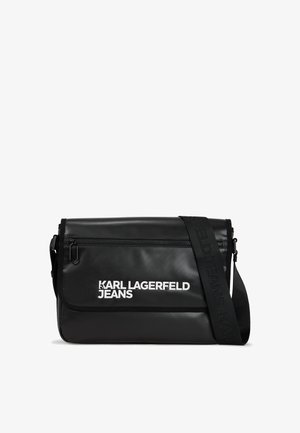 Bolsa de mensajero negra hecha de material texturizado, con un bolsillo con cremallera, correa ajustable y detalles en blanco del logo en la parte frontal.