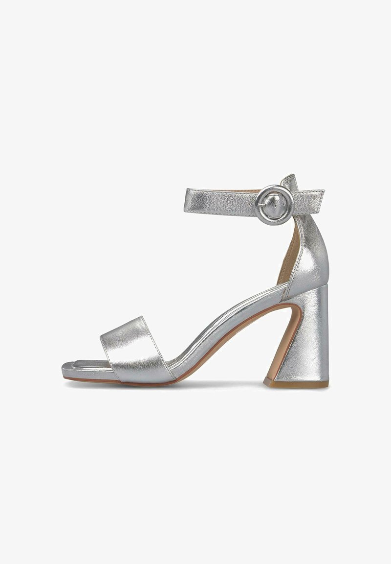 Srebrny sandał na obcasie z teksturowanym metalicznym wykończeniem, otwarty czubek, pasek wokół kostki z okrągłą klamrą i geometryczny blokowy obcas.