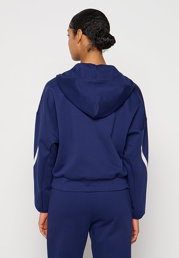 Navyblaues Sweatshirt aus weichem Stoff, mit einer großen Kapuze und weißen Akzentstreifen an den Ärmeln. Lässige Passform und entspanntes Design.