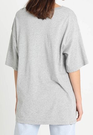 Grå bomulds t-shirt i oversized pasform med droppede skuldersømme, rund halsudskæring og afslappet fit. Glat tekstur og minimalistiske designdetaljer.