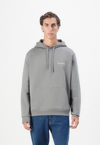 Grå hettegenser med frontlomme, ribbede mansjetter og kant. Har "ALLSAINTS"-logo i hvitt på venstre bryst. Behagelig tekstur på stoffet.