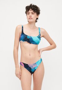 Bikini set obsahujúci top bez ramienok a nízko strihané spodky. Vyrobený z farebného elastického materiálu s kvetinovými vzormi v modrej, ružovej a čiernej farbe.