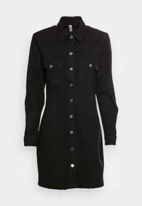 Musta farkkimekko, jossa on pitkät hihat, napitettava etuosa, kaksi rintataskua ja hopeinen varuste. Mekossa on rakenteellinen kaulus ja muotoiltu siluetti.