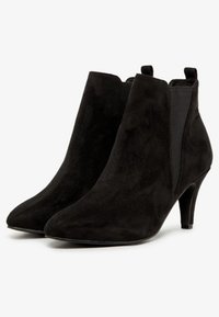 Schwarze Wildleder-Stiefeletten mit spitzer Zehenpartie und einem 3-Zoll-Absatz. Mit elastischen seitlichen Einsätzen für einen einfachen Einstieg und einer glatten, strukturierten Oberfläche.