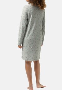 Długosleeve nightdress z jasnozielonego materiału, z kwiatowym wzorem. Miękka tekstura, długość do kolan i okrągły dekolt.