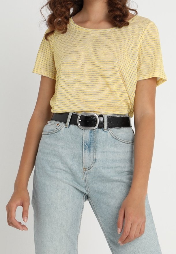 Femme portant un t-shirt rayé jaune à manches courtes, rentré dans un jean bleu clair taille haute avec une ceinture noire et une boucle argentée.
