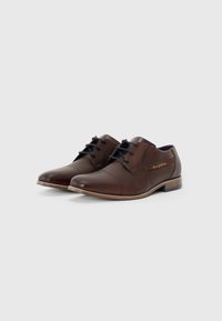 Zapatos de vestir de cuero marrón con punta redondeada, diseño de cordones y detalles de costura sutil; tacón de madera y acento de logotipo en el lateral.