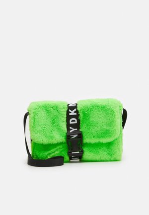 Sac vert feutré avec un rabat, équipé d'une bandoulière noire marquée et d'une bandoulière réglable. Texture douce avec des éléments de design carrés.