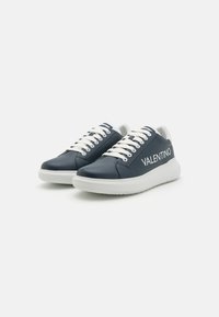 Marine leren sneakers met witte veters en zool. Kenmerkt de "VALENTINO" branding aan de zijkant in witte tekst. Ronde neus en laag ontwerp.