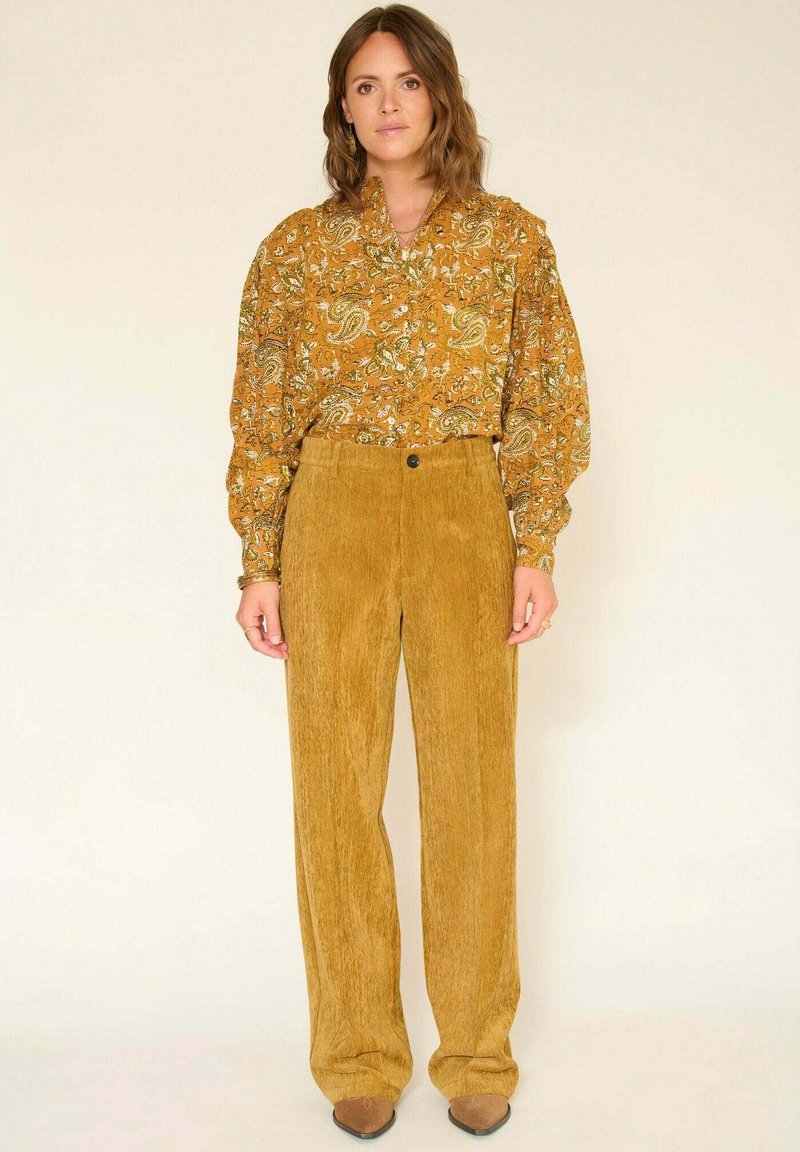 Blouse à manches longues à imprimé cachemire jaune avec une coupe décontractée, associée à un pantalon en velours côtelé moutarde côtelé taille haute.