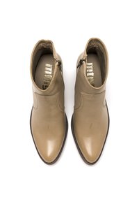 Botines de piel beige claro con punta afilada, cierre de cremallera lateral y un acabado suave. El interior presenta un logotipo dorado brillante.