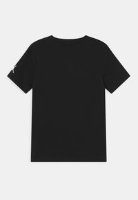 Svart t-shirt med kort ärm och rund halsringning, enfärgad baksida och liten vit silhuettlogotyp på vänster ärm.