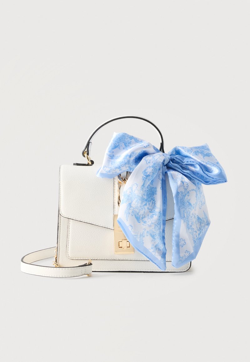 Sac à main en cuir blanc avec fermoir et poignée dorés, décoré d'un grand foulard de soie bleu et blanc à motifs, noué en nœud.