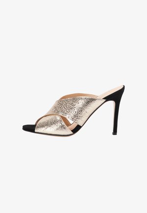 Goldmetallisches Leder-Obermaterial, schwarzes Wildleder-Design mit offenen Zehen und gekreuzten Riemen, schlanker Stiletto-Absatz, glatte Innenauskleidung und strukturierte Oberfläche.