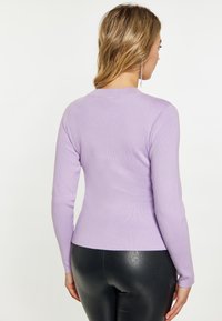 Lila Langarmpullover mit einer figurbetonten Passform und geripptem Textur. Die Rückansicht zeigt einen klassischen Rundhalsausschnitt und glattes Material.