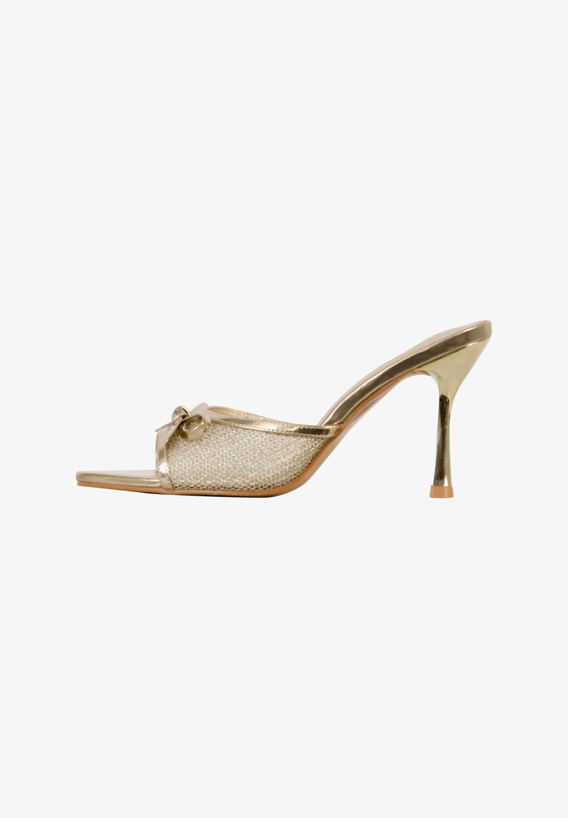 Mule à talons hauts dorée avec une tige en maille et un petit nœud décoratif sur l'avant, dotée d'un talon stiletto fin.