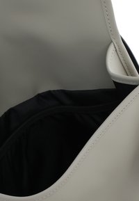 Borsa in finta pelle grigia con interno in tessuto nero, caratterizzata da una grande apertura e un design curvo, con dettagli cuciti lungo i bordi.
