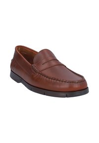 Mocasín de cuero marrón con un detalle de costura, suela plana de goma y un acabado suave. Presenta un diseño sin cordones para facilitar su uso.