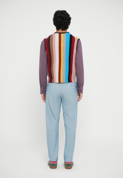 Gilet lavorato a maglia multicolore con strisce verticali, abbinato a pantaloni a righe blu chiaro, progettati con una linea dritta e una vestibilità casual.