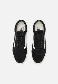 Sneakers in suede nero con strisce laterali bianche, punta rotonda, design con lacci e suola in gomma bianca. Parte superiore testurizzata e punta rinforzata.