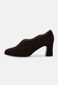 Décolleté in camoscio marrone con punta affilata, tacco basso a blocco, texture liscia e design sottile e curvo lungo la tomaia.