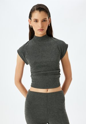 Top recortado de textura gris con cuello alto y mangas de farol, con un diseño fruncido. Material de punto suave con un patrón vertical.