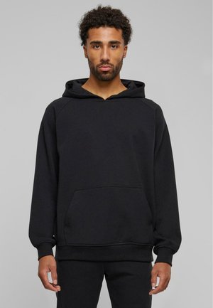 Sort hoodie lavet af blødt stof med en kengurulomme, hætte og ribbede manchetter. Har en afslappet pasform og raglanærmer.