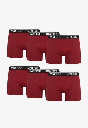 Boxer in cotone rosso con una vita nera con il logo "INDICODE"; sei paia esposti in una pila, mostrando viste frontali e posteriori.