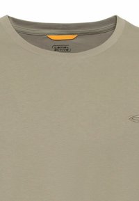 Jasno beżowy t-shirt z okrągłym dekoltem, wykonany z miękkiego materiału, z małym haftowanym logo w podobnym odcieniu. Gładka tekstura, minimalistyczny design.