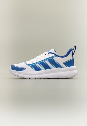 Baskets blanches et bleues avec lacets à l'avant, languette bleue au talon et semelle rembourrée sur fond neutre.