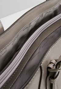 Intérieur en cuir texturé gris avec une poche zippée et une doublure en tissu imprimée du motif logo « MICHAEL KORS ». 