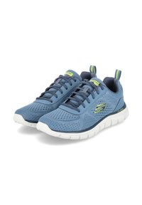 Scarpe sportive in rete blu con superficie testurizzata, suola bianca e accenti grigi. Presentano un design con lacci e un pratico pull tab sul retro per indossarle facilmente.