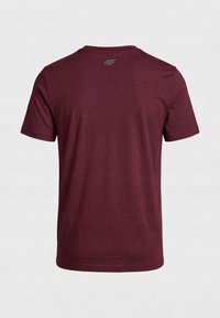 T-shirt bordeaux uni à manches courtes vu de dos avec un petit logo gris "4F" près de l'encolure.