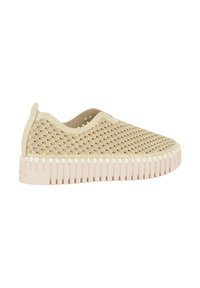 Zapato beige sin cordones con parte superior texturizada de patrón ondulado y suela de goma gruesa y estriada. Presenta recortes para ventilación.