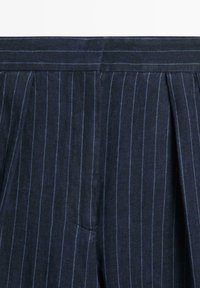 Donkerblauwe broek met dunne verticale lichtblauwe krijtstrepen en een tailleband met een verborgen ritssluiting aan de voorkant.